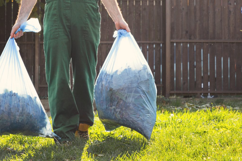 the gardener removes the bags of compost. light. green uniform. close up